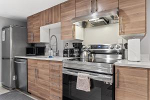 a kitchen with stainless steel appliances and wooden cabinets at Walk to Parks Restaurants Monuments & More in Washington, D.C. +13 photos