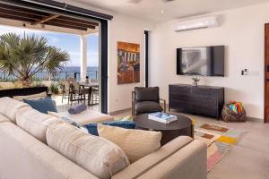 a living room with a couch and a tv and a table at Boutique Ocean Escape with Relaxing Amenities in El Pescadero