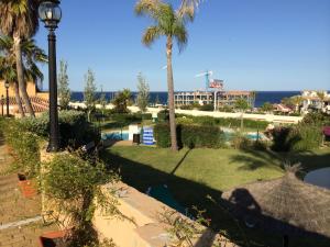 Blick auf einen Park mit Palmen und einem Pool in der Unterkunft La Galera Park House in Estepona