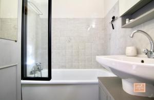 ラ・セーヌ・シュル・メールにあるEscapade cornicheの白い浴槽と洗面台のあるバスルーム