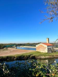 an old building on the side of a river at Lodge Casonetto in Rosolina Mare