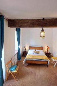una camera da letto con un letto grande e due sedie di Maison de vacances dans grand jardin arboré à La Chapelle-Saint-Fray proche Le Mans Sarthe, Pays-de-la-Loire a Domfront-en-Champagne