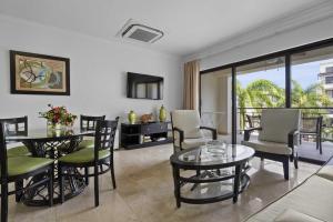una sala de estar con una mesa y sillas en PC314 - Pool View - Couple or Family with kids - 1BR, en Palm-Eagle Beach