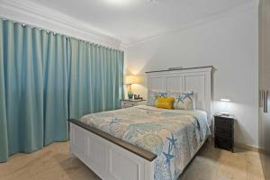 Un dormitorio con una cama grande con cortinas azules. en PC412 - Pool View - 1BR Perfect for a couple or Family - Close to Palm Beach - 1BR, en Palm-Eagle Beach 40 fotos más