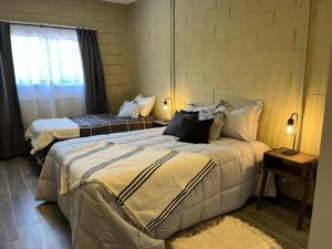 a bedroom with two beds and a window at A solo 15min del aeropuerto EZEIZA in Ezeiza