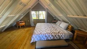 1 dormitorio con cama y ventana en el ático en La Casona entre el Bosque, en Guatemala