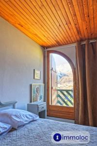 Un dormitorio con una cama y una ventana grande. en AURON Duplex apartment, en Auron 8 fotos más