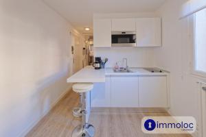 a white kitchen with a counter and a sink at Studio Place d'Auron in Auron