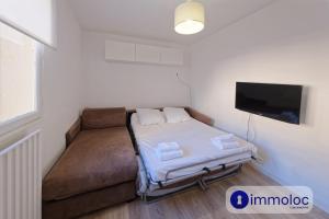a small room with a couch and a flat screen tv at Studio Place d'Auron in Auron