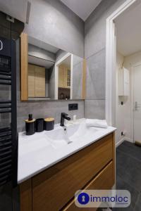 a bathroom with a white sink and a kitchen at Studio Auron 300 meters from the cable car in Auron