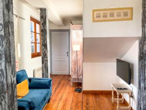 a living room with a blue couch and a tv at La Maison Bleue - Historic House in the Heart of Riquewihr in Riquewihr +153 photos