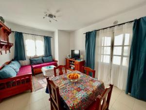 a living room with a table with a bowl of oranges on it at Penthouse prés médina avec vue mer et terrasse in Sousse