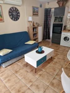 a living room with a blue couch and a coffee table at Gite l'Embellido in Mouriès