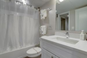 een badkamer met een wastafel, een toilet en een spiegel bij Sojourn Courtland Towers 2 BR in Arlington +26 foto's