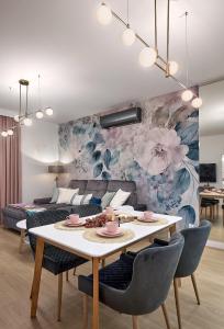 una sala de estar con una mesa y un sofá en Boszkowo Horizon Park Apartament 36 "Kwiecisty sen", en Boszkowo