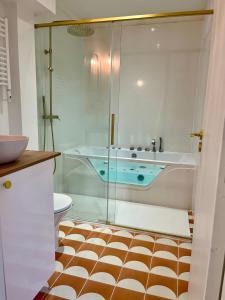 bagno con vasca e doccia in vetro di Le Bellegarde - hypercentre et jacuzzi a Tolosa