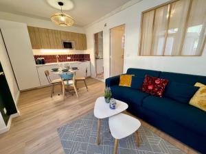 a living room with a blue couch and a table at Le Bellegarde - hypercentre et jacuzzi in Toulouse