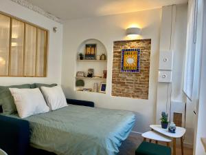 a bedroom with a bed and a brick wall at Le Bellegarde - hypercentre et jacuzzi in Toulouse