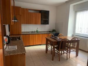 a kitchen with a table and chairs and a kitchen with a sink at L edera Gigante in Civezzano