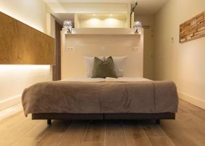 een slaapkamer met een groot bed met twee kussens bij Hotel Noudus in Delfstrahuizen