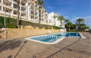 a swimming pool in front of a large building at Gorgeous Apartment In Santa Pola in Santa Pola +22 photos