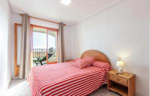 a bedroom with a bed with a red and white striped blanket at Gorgeous Apartment In Santa Pola in Santa Pola