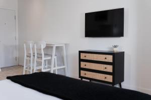 a bedroom with a bed and a desk and a tv at #8 - Refined Studio - Self Check in - Plateau - St-Denis - AC - TV in Montréal