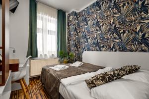 Great Polonia Dwarf Wrocław في فروتسواف: غرفة نوم بسرير وورق جدران ازرق وابيض