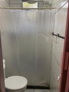 un bagno con un water e una tenda da doccia di Host dos Anjos II ad Arraial do Cabo Altre 8 foto