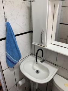 bagno con lavandino e asciugamano blu di Host dos Anjos II ad Arraial do Cabo