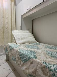 una camera da letto con un letto con un cuscino e una finestra di Host dos Anjos II ad Arraial do Cabo