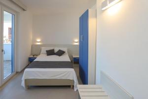 una piccola camera da letto con un letto e una finestra di The Square Castelsardo a Castelsardo