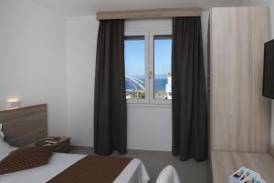 una camera da letto con finestra affacciata su un ponte di The Square Castelsardo a Castelsardo