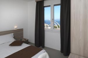 una camera da letto con un letto e una grande finestra di The Square Castelsardo a Castelsardo