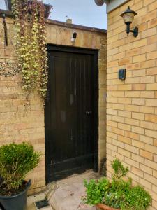 a black garage door on a brick building at Woodstock Studio in Woodstock
