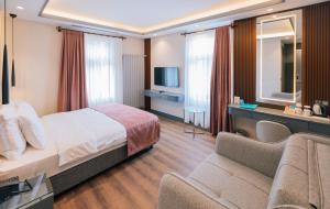 a hotel room with a bed and a couch at VE Hotels Adakale in Yenişehir +22 photos