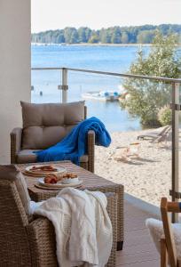 a table with a plate of food and a view of a beach at Boszkowo Horizon Park Apartament 17 in Boszkowo