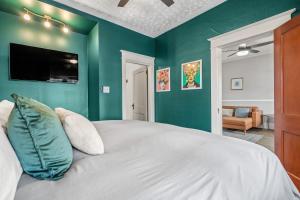 a bedroom with green walls and a large bed at Dinos Last Post - Family Friendly 4 Bedrooms in Drumheller