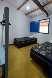 una habitación con dos camas y una ventana en Casinha da porteira, en Divino de São Lourenço
