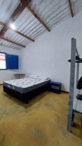 Una habitación con una cama en el medio. en Casinha da porteira, en Divino de São Lourenço