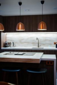 a kitchen with a sink and two bar stools at 4009 loft penthouse Prince des Cimes Arc 1950 in Arc 1950 +45 photos