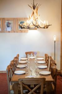 a long wooden table with chairs and a chandelier at 4009 loft penthouse Prince des Cimes Arc 1950 in Arc 1950
