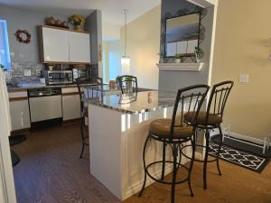 a kitchen with bar stools and a counter top at Entire 2-bedroom, 2 bath home with parking and newly renovated floors in Canton +9 photos