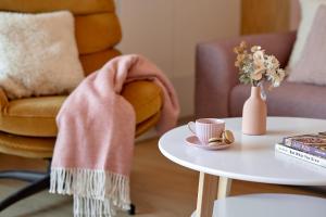 a coffee table with a pink blanket and a coffee cup at Boszkowo Horizon Park Apartament 27 "Romantic" in Boszkowo