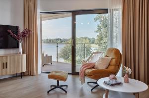 a living room with a chair and a large window at Boszkowo Horizon Park Apartament 27 "Romantic" in Boszkowo