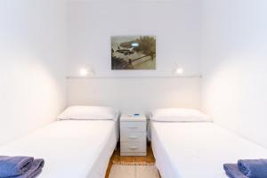 Habitación con 2 camas individuales y paredes blancas. en TrendyHomes Retamar III - Playa, piscina y golf, en Almería 16 fotos más