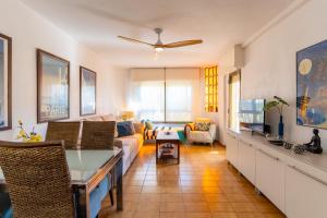 una sala de estar con un sofá y una mesa en TrendyHomes Retamar III - Playa, piscina y golf, en Almería