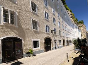 a large stone building on a cobblestone street at Citycenter Salzburg am Ursulinenplatz in Salzburg
