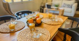a wooden table with plates of fruit and glasses of orange juice at AC - PRIVATE Exterior - Au pied du palais des papes! in Avignon