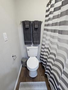 a bathroom with a white toilet and black towels at The Comfort Cove in Cleveland